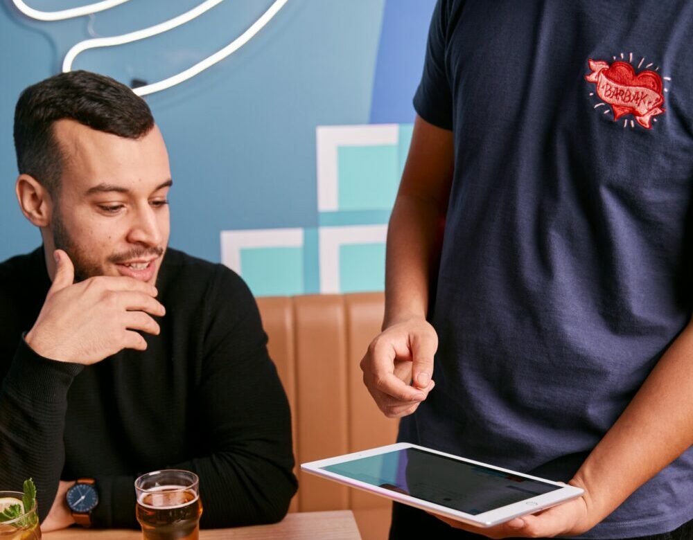 A waiter is advising a diner.